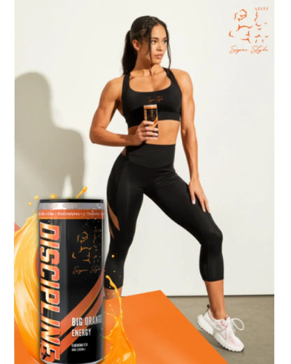 Athletic woman in black activewear holding a Super Style Discipline Big Orange Energy drink can, promoting clean energy, focus, and fitness lifestyle.