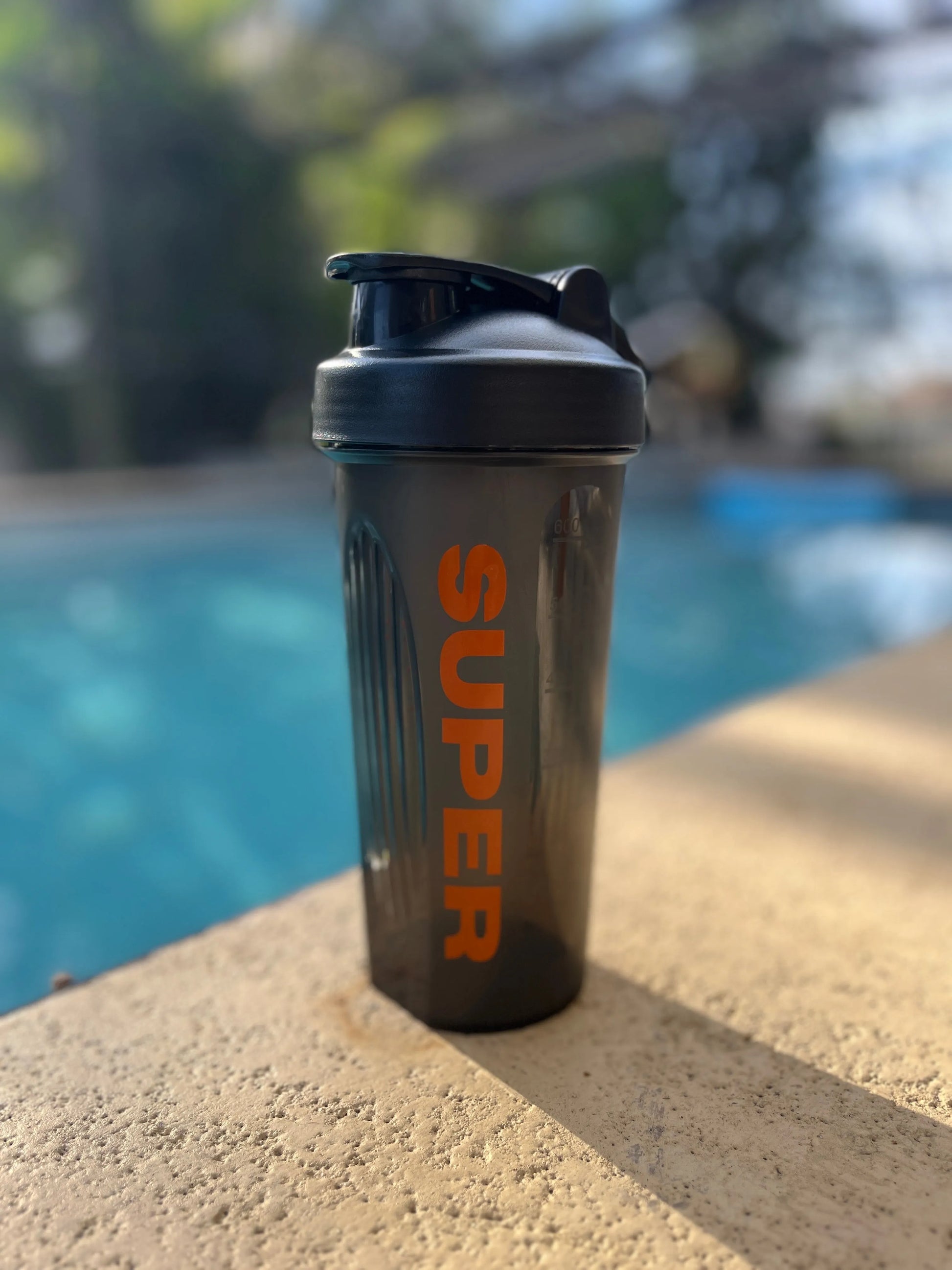 Super Style 16 oz shaker with dark translucent bottle, black lid, and wire ball mixer.