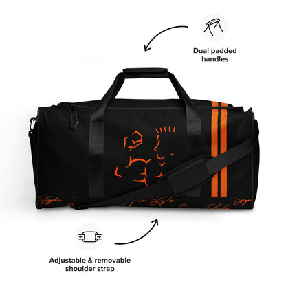 Black duffel bag with orange accents featuring dual handles and an adjustable shoulder strap on a white background.